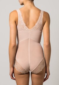 Nude bodysuit with a V-shaped lace back, wide straps, and lace trim along the bottom edges; smooth texture and fitted design.