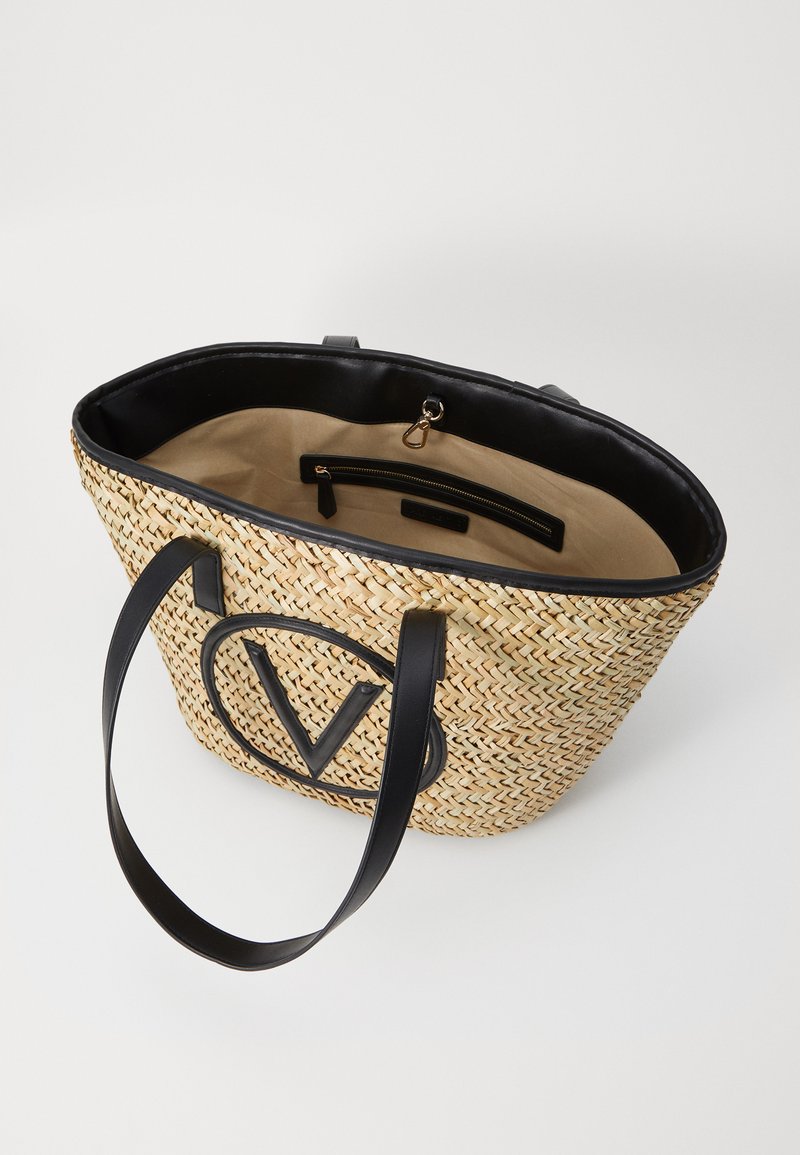 Sac en paille tressée avec des accents en cuir synthétique noir, grand logo "V" sur le devant, et un intérieur doublé en tissu avec des poches.