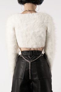 Hvit, luftig, kortermet genser parret med høyt liv svarte skinnbukser med lommer og en sølvkjede detalj.