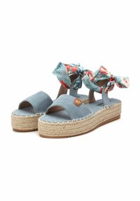 Sandalias de esparto de tela azul con plataforma, punta abierta y dos lazos con estampado floral en las correas. Acentos de yute trenzado en la suela.