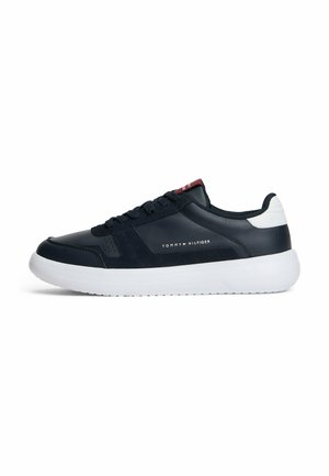 Zapatilla baja de Tommy Hilfiger en azul marino y blanco, con frente de cordones y suela blanca acolchada, logo de la marca en el lateral y en la lengüeta.