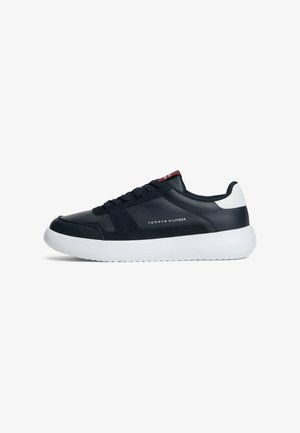 Navy blue and white Tommy Hilfiger low-top sneaker with lace-up front and cushioned white sole, brand logo on side and tongue.