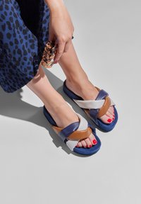 Multicolored flip-flop sandals with a navy, brown, and beige design. The straps are soft leather; the soles are cushioned and textured.