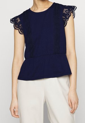 Marineblaues Peplum-Oberteil mit spitzenbesetzten Kapuzenärmeln und vertikalen, strukturierten Paneelen, gefertigt aus weichem Stoff. Schlichter Rundhalsausschnitt.