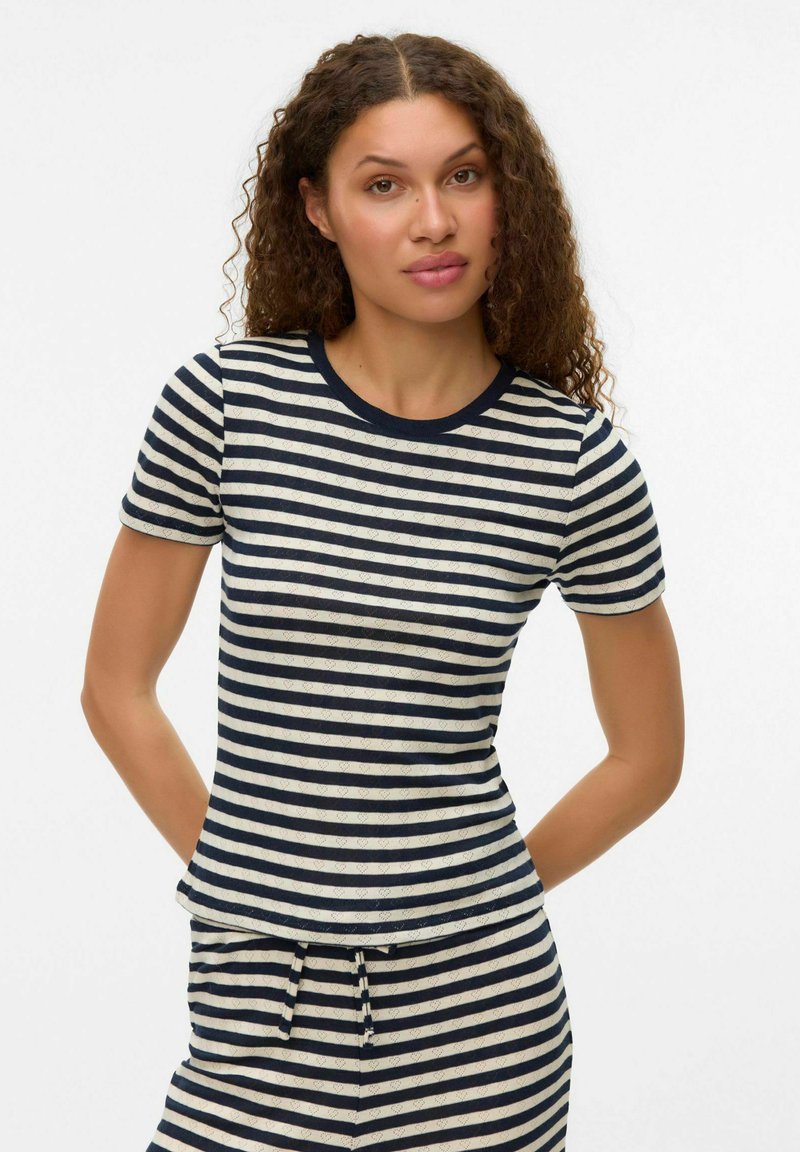 Navy og creme-stribede kortærmede t-shirt med en tætsiddende design, rund hals og glat tekstur; parret med matchende stribede bukser.