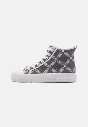 High-top sneaker met zwart-wit patroon stof, witte zool, veters en "MICHAEL KORS" in reliëf op de hiel.