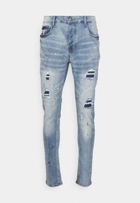 Light blue denim jeans with a slim fit. Features distressed areas and paint splatters. Classic five-pocket design and button closure.