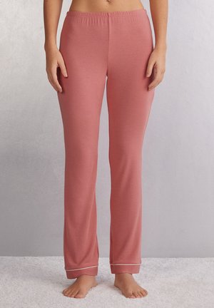 Lichtroze katoenen pyjamabroek met een elastische tailleband, uitlopers en een contrasterende witte bies bij de enkel. Zachte, gladde textuur.