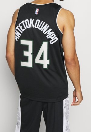 Man wearing black basketball jersey and shorts, jersey shows NBA logo, name "Antetokounmpo," and number 34 on the back.