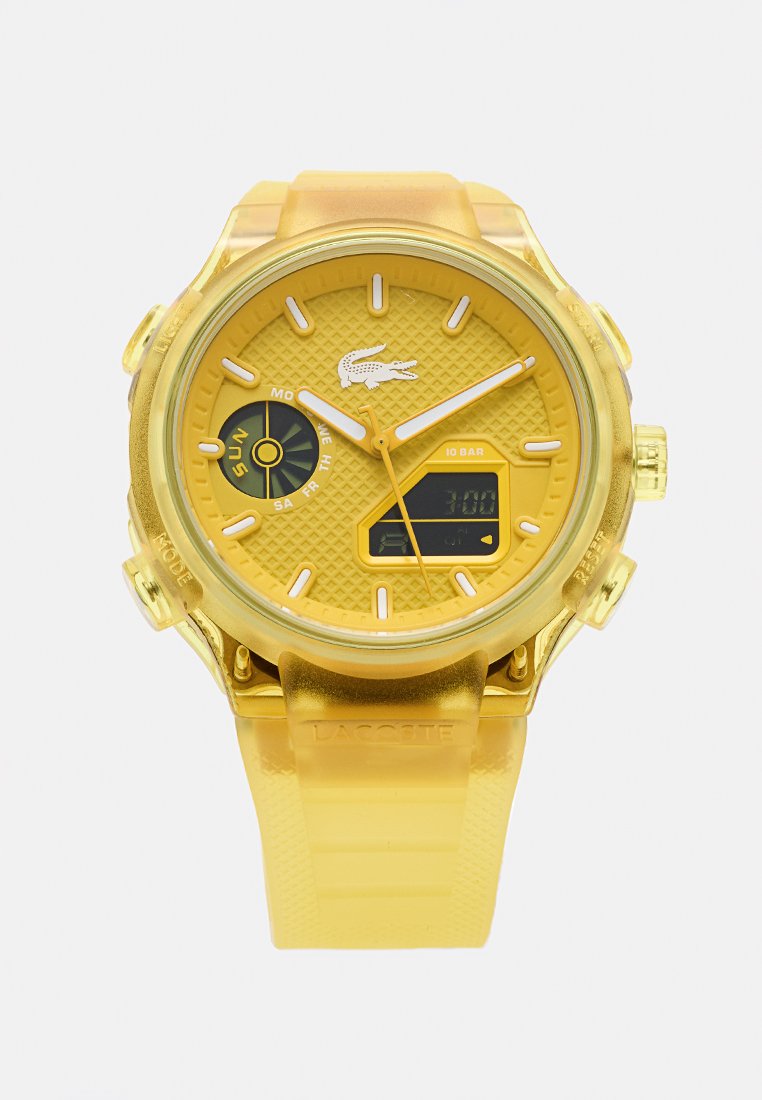 Reloj de pulsera Lacoste amarillo con pantallas analógica y digital, esfera texturizada y subesfera de día de la semana con sol, sobre un fondo liso.