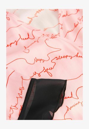 Jasnoróżowy materiał z czerwonymi ręcznie napisanymi wzorami, z czarnymi przezroczystymi akcentami wzdłuż krawędzi i gładką teksturą.