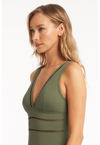 Olijfgroene zwemkleding met een diepe halslijn, racerback ontwerp en getextureerde bandaccenten. Glad materiaal met een getailleerde pasvorm.