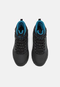 Scarpe da trekking impermeabili nere con tomaia in mesh e sintetico, imbottitura teal a contrasto, lacci grigi e suola in gomma testurizzata.