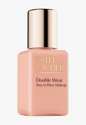 Flacon de fond de teint Estee Lauder Double Wear en teinte pêche. Forme carrée avec un bouchon doré. Texte noir au recto indiquant "Double Wear Stay-in-Place Makeup".