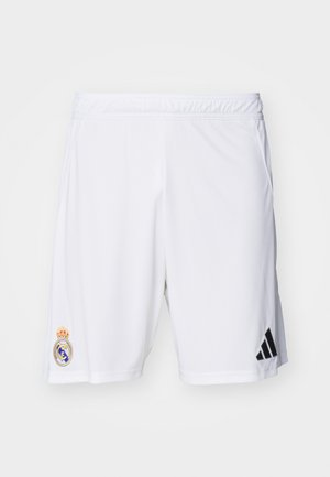 Pantaloni sportivi bianchi realizzati in tessuto leggero, con il logo Adidas nero e il distintivo ricamato del Real Madrid sulla gamba sinistra.