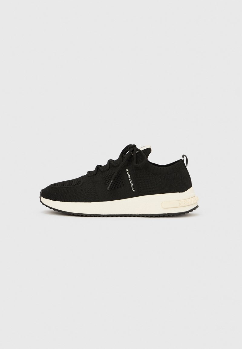 Baskets en tricot noir avec semelle blanche, design à lacets, languette au talon et texte "Armani Exchange" sur le côté.