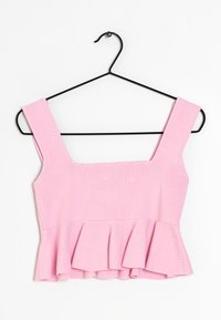 Roze peplumtop van ribstof. Vierkante halslijn, brede bandjes en uitlopende zoom. Hangt aan een zwarte metalen hanger.