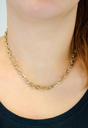 Goldene Halskette aus ovalen Gliedern mit glatter Oberfläche. Um den Hals getragen, gegen ein dunkles Hemd.