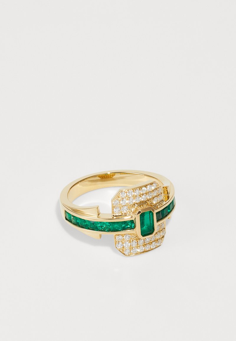 Gold ring featuring an emerald-cut emerald at the center and a band with green gemstones. Surrounded by small, clear, sparkling stones.