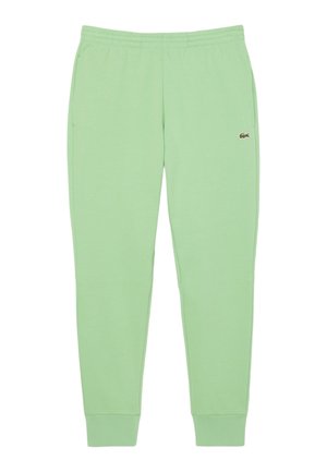 Pantalones de chándal verde claro hechos de una tela suave, con una cintura elástica, bolsillos laterales y un pequeño logo en el muslo izquierdo.