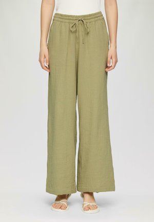 Pantalons larges en vert olive en tissu texturé, avec une taille élastique et un cordon de serrage. Comprend deux poches latérales.