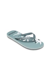 Kumar flip-flop teal dengan pola bunga putih. Memiliki alas kaki yang bertekstur dan desain tali tunggal. Logo Quiksilver pada tali.
