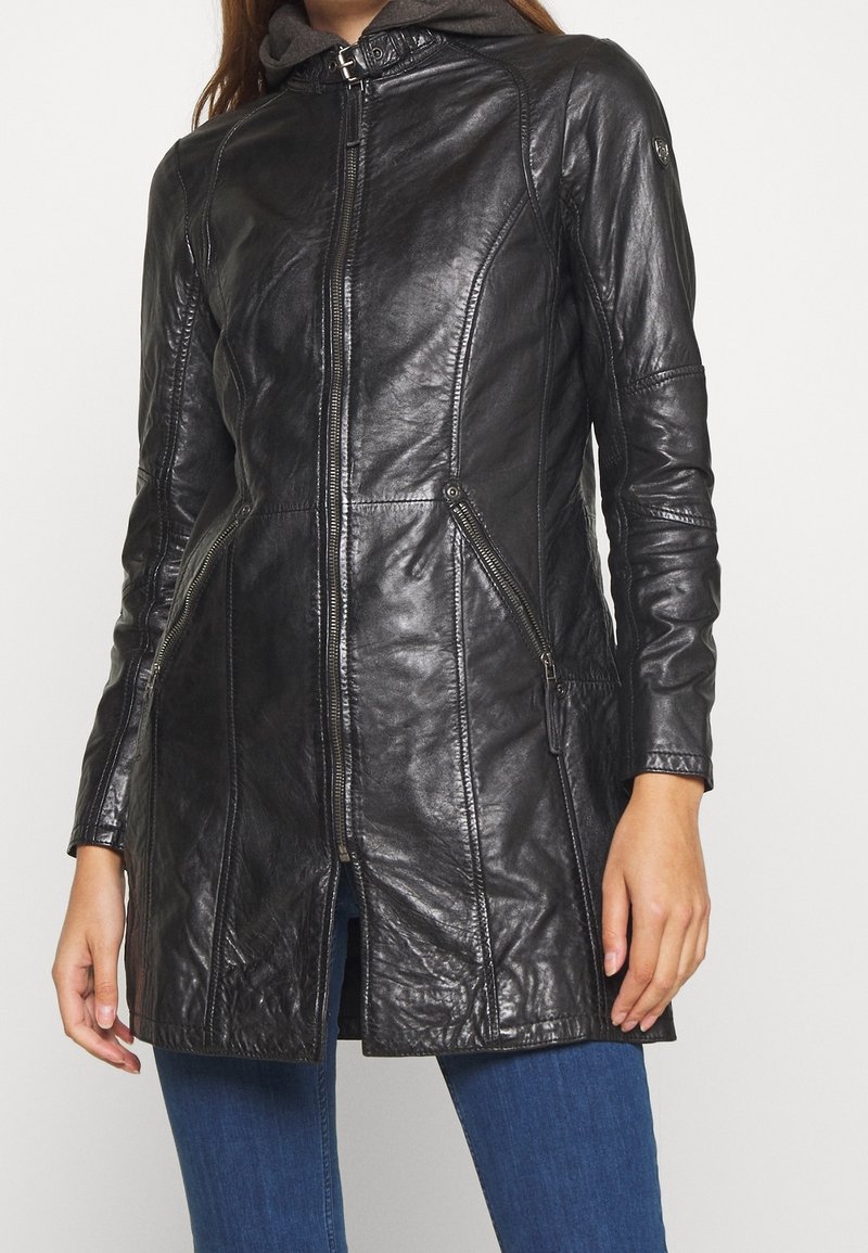 Schwarze Lederjacke mit Reißverschluss vorne, tailliertem Design und seitlichen Reißverschlusstaschen. Sie zeichnet sich durch eine glatte Textur und eine leicht verlängerte Form aus.