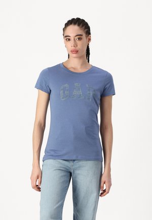 T-shirt blu a maniche corte in cotone, con logo "GAP" testurizzato in una tonalità più scura. Collo rotondo e silhouette aderente.