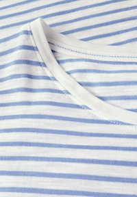 Cotton T-shirt med vandrette blå og hvide striber, rund halsudskæring og en blød tekstur. Søm detaljer er synlige.