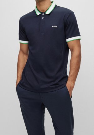 Granatowa koszulka polo z zielonymi i białymi paskami na kołnierzyku i mankietach. Posiada rozcięcie z trzema guzikami i logo "BOSS" na piersi.