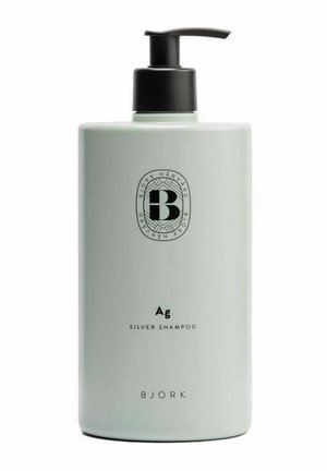 Høj, lysegrå shampooflaske med sort pumpe, mærket "Ag Silver Shampoo" og Björk-branding med cirkulært logo foran.
