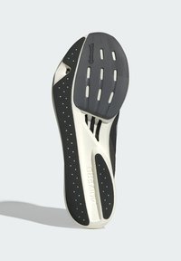 Schwarze und weiße Laufsohle eines Sportschuhs mit strukturiertem Oberflächen, Löchern für Grip und einer EVA-Schaumlage mit "ADIZERO"-Branding.