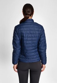 Granatowa kurtka puchowa z pikowanym wzorem, z kołnierzem stójkowym i długimi rękawami. Gładka, błyszcząca tekstura. Widok z tyłu.