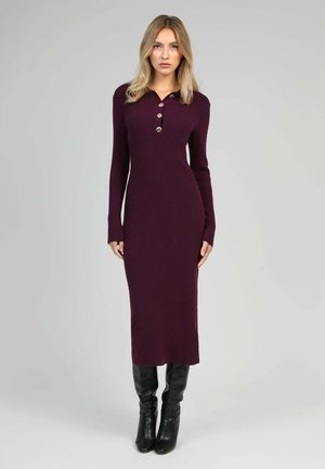 Robe en maille côtelée violet foncé avec col, patte de boutonnage à quatre boutons et manches longues, associée à des bottes en cuir noires montantes jusqu'au genou.