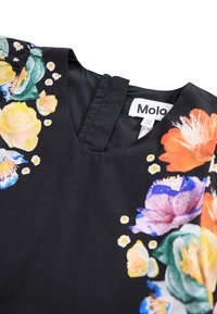 Black garment featuring a floral pattern in vibrant colors, with a round neckline and a smooth texture. Tag visible with brand name "Molo."