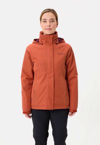 Giacca impermeabile color ruggine con collo alto, cappuccio regolabile e interno viola, con un logo sul petto e design aderente.