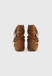 Brown suede ankle boots with gathered texture, decorative fringes, and layered straps, featuring a rounded toe and rubber sole.