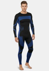 Men's athletic set featuring a fitted long-sleeve top and leggings in black with blue and black wave patterns, made from stretchable fabric.