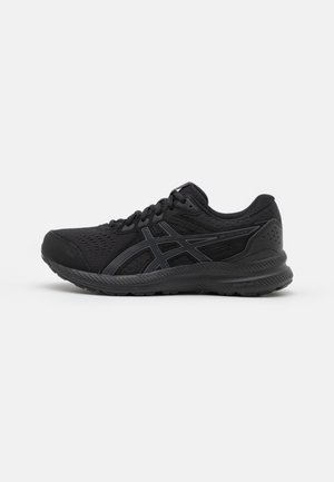 Chaussure de course athlétique noire avec dessus en mesh, semelle en caoutchouc, lacets et détail du logo de la marque sur le côté.