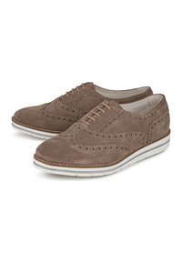 Ruskeat mokkasaappaat, joissa on brogue-yksityiskohtia, nauhakiristys ja valkoinen kumipohja, jossa on beige korostusraita.