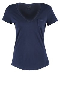 T-shirt bleu marine à manches courtes pour femme avec col en V, petite poche poitrine et ourlet arrondi, marqué GAP à l'intérieur du col.