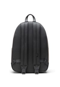 Sac à dos en tissu gris foncé avec une forme arrondie. Équipé de bretelles rembourrées, d'une poignée supérieure et de coutures visibles le long du dos.