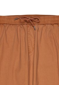 Bruna dragsnörshorts gjorda av mjukt tyg, med ett rynkat midjeband och en framficka. Slät textur med minimala sömnadsdetaljer.