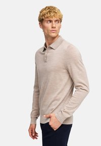 Helle beige Langarm-Polo mit Kragen, Drei-Knopf-Leiste und gerippten Bündchen. Weicher Strickstoff mit subtilen Nähten.
