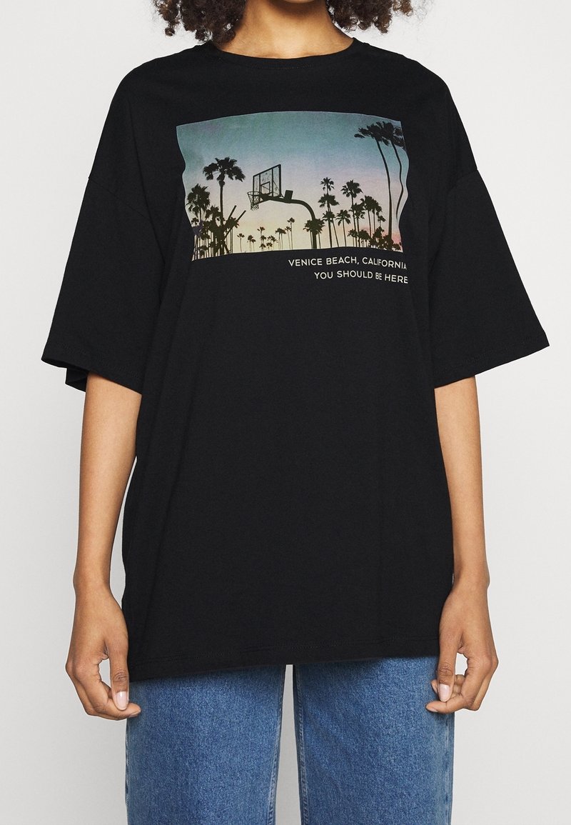 Czarny, oversize'owy t-shirt wykonany z bawełny, z nadrukiem graficznym przedstawiającym palmy i kosz do koszykówki oraz tekstem "Venice Beach, Kalifornia."