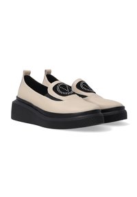Béžové kožené slip-on boty s černým textilním akcentem v podobě srdce. Silná černá gumová podrážka s texturovaným vzorem.