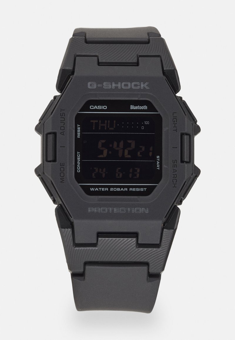 Montre numérique G-Shock noire avec un boîtier hexagonal, bracelet en caoutchouc, affichage LCD, connectivité Bluetooth et étanchéité jusqu'à 20 bars.