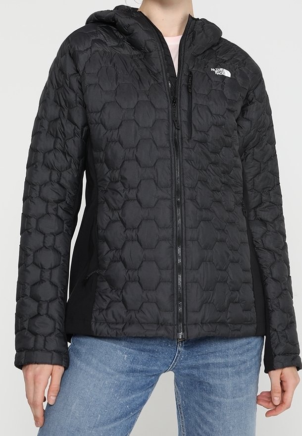 Giacca nera isolante con texture a trapunta esagonale, cappuccio e zip frontale. Presenta tasche laterali e pannelli neri a contrasto.