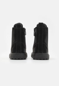 Czarne botki za kostkę z gładkiej zamszowej skóry, wzmocnionymi szwami, gumową podeszwą oraz bocznym zamkiem idealnym do zakładania.