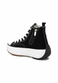 Zapatillas altas de lona negra con cordones blancos, que cuentan con una cremallera lateral y una suela plataforma blanca gruesa con una suela exterior negra texturizada.